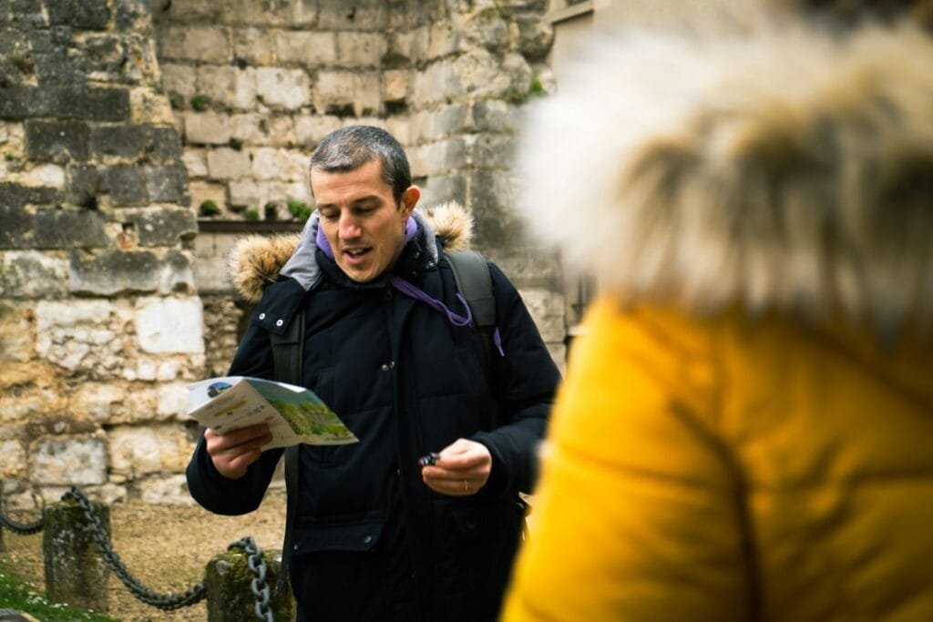  private tour guide consults a map while leading a group, highlighting the expertly planned and guided excursions included in a custom travel package.