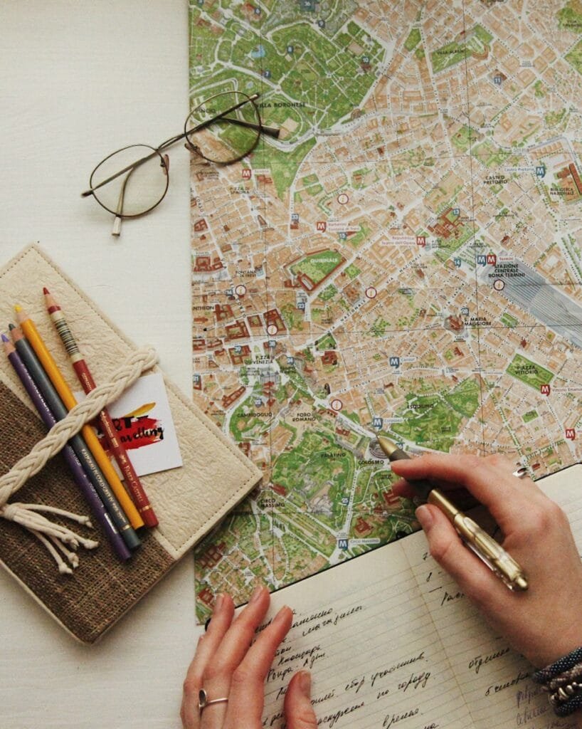 Meticulously organized travel planning documents, including a custom map and itinerary, showcasing the detailed work of a personal travel designer.